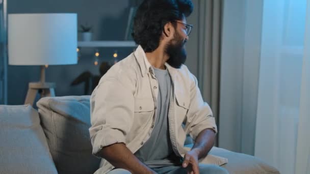 Frustrato deluso indiano arabo uomo barbuto tifoso maschio seduto a casa sera sullo schermo della TV in salotto buio e guardando online calcio tifoso preoccupazione di perdere partita partita partita di sport gioco — Video Stock