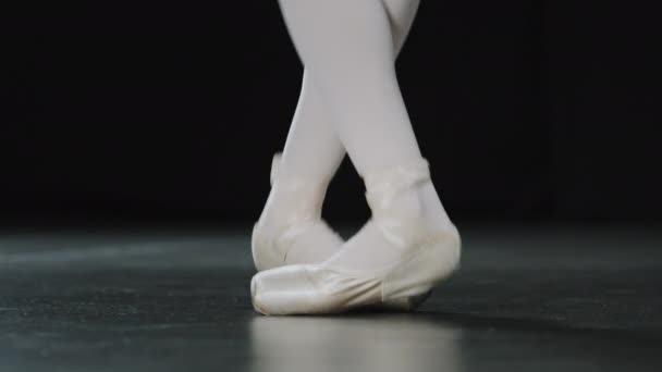 Ballerine jambes féminines gros plan dansant sautant debout sur les orteils position de ballet pratiquant la répétition sur scène parquet effectuant des mouvements danseur méconnaissable dans des chaussures pointe pieds de danse actifs — Video