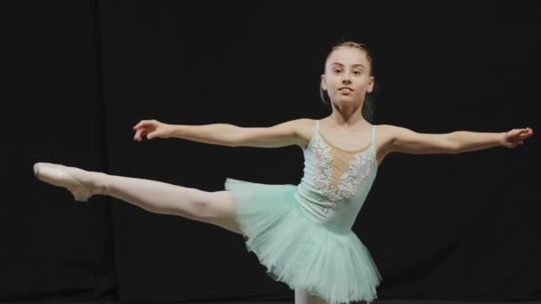Маленькая балерина девочка-подросток в пачке делает балетную позу позицией баланс на одной ноге упражнения расстроен беспокойство из-за неудачи проблема падения жесткий урок хореографии в танцевальном классе — стоковое видео