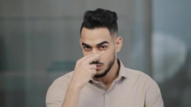 Ciddi Arap işçi girişimci başını iki gözünü işaret ederek gösteriyor ki sen işaret ediyorsun İspanyol asıllı iş adamını uyaran iş arkadaşı güvensizliğini gösteriyor.