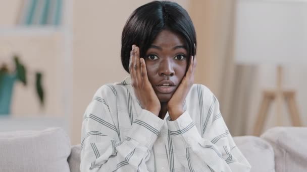 Detailní záběr mladá africká americká užaslá žena drží ruce na tváři šokované emocemi říká wow překvapený učení neuvěřitelné novinky pocit šok usmívání překvapení úžas emocionálně překvapující — Stock video