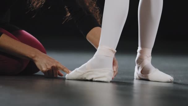 不知名的女教练老师教女孩芭蕾手站在尖鞋上做经典的腿姿势舞蹈芭蕾课和个人教练的脚伸展舞蹈课练习 — 图库视频影像