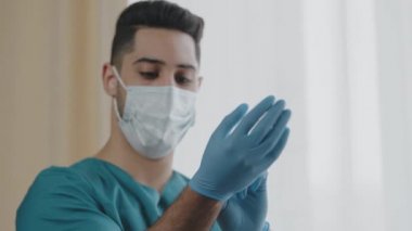 Hastane Arap erkek işçi cerrahı. Eldiven takıyor. İç klinikte özel koruyucu tıbbi maske takıyor.