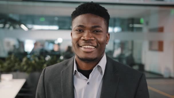 Młody człowiek millennial amerykański afrykański biznesmen zespół lider biuro dyrektor generalny w profilu pozowanie zadowoleni patrząc w aparat z uśmiechem zębów stojąc blisko widok mężczyzna portret — Wideo stockowe