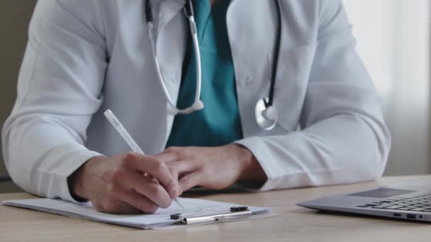 Kwalifikowany terapeuta ze stetoskopem wypełniającym formularz medyczny zauważający odbiór kończący leczenie przepisującym pacjentowi męskiego lekarza wypisującego szczegółową receptę na tabletki — Wideo stockowe