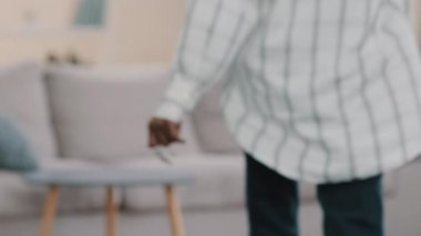 Yakın çekimde daire anahtarları genç mutlu Afro-Amerikalı kadın eğlencesine kanepeye düşüyor yeni ev almaktan keyif alıyor rahat oturma odasının tadını çıkarıyor mutlu bir şekilde gülümsüyor keyif alıyor rahatlığı sağlıyor