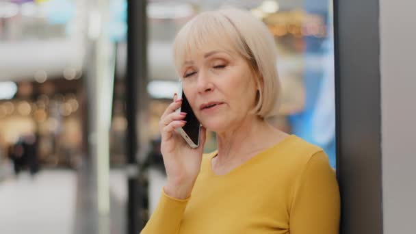 Крупный план зрелого среднего возраста кавказская серьезная женщина говорит по телефону отвечая на деловой звонок говорит с другом с помощью смартфона удаленной связи с помощью мобильных технологий обсуждения проблемы по телефону — стоковое видео