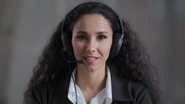 Latin kökenli genç bayan strese dirençli banka çalışanı kameraya mikrofon ile bakıyor gelen arama müşterileri destek servisi müşterileri kavramını destekliyor.