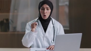 Müslüman sinir bozucu kadın başhekim kamera karşısında agresifçe bağırıyor. Kendi bakış açısıyla kalem sorununu çözüyor. Duygusal kaotik işaret.