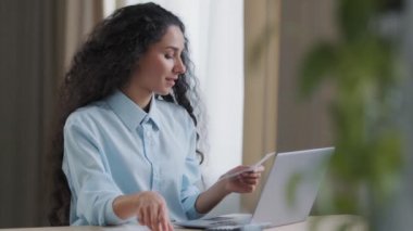 Odaklanmış iş kadını İspanyol muhasebeci bilgisayar başvurusunda kişisel aylık bütçe çekini yönetiyor. Mali raporun hesaplamasını yapıyor. Faturayı internet üzerinden ödüyor.