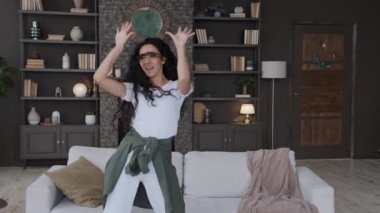 Genç, mutlu, neşeli, çılgın bir kadın. Oturma odasında, favori müziğiyle dans ediyor. Kafasını sallıyor, koltukta uzun kıvırcık saçlar zıplıyor.
