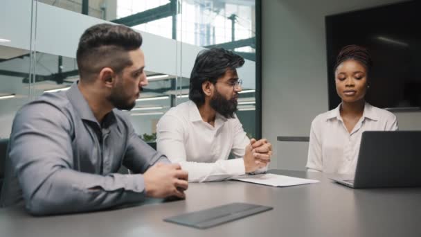 Πολυεθνική επιχειρηματική ομάδα ποικίλοι άνθρωποι brainstorm στο γραφείο δύο Άραβες άνδρες και Αφρικανή γυναίκα χρησιμοποιώντας φορητό υπολογιστή συζητώντας ομάδα startup συναδέλφους συζητούν εταιρικό λογισμικό του έργου ομαδική εργασία — Αρχείο Βίντεο