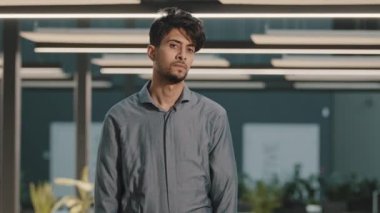 Düşünceli, düşünceli Arap iş adamı profilinin portresi yüzünü çevirmiş kameraya bakıyor. Kapalı alanda çapraz silahlarla poz veriyor. Modern ofis hayal kırıklığına uğramış işçi memnuniyetsiz bir ifade sergiliyor.