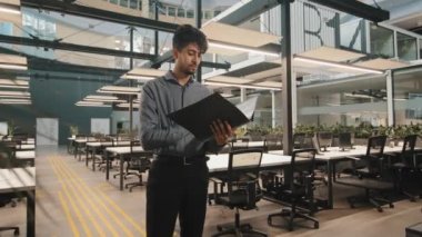 Genç Hintli Latin menajer erkek işadamı. Belge klasörüne bakıyor. Mali raporları inceliyor.