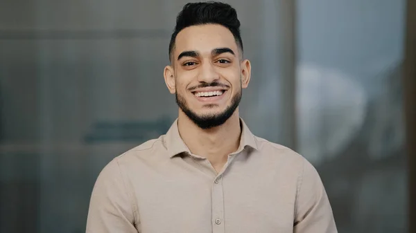 Happy young guy hispanic handsome man with toothy smile looking at camera male face portrait businessman smiling arab professional manager entrepreneur posing positive in modern office close up view — 스톡 사진