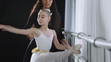 Klasik dansın kadın koreograf öğretmeni eğitmeni, genç öğrencilere esneme hareketleri öğreterek, dans etmeyi öğrenmelerine yardımcı oluyor. Jimnastik dersi veriyorum.