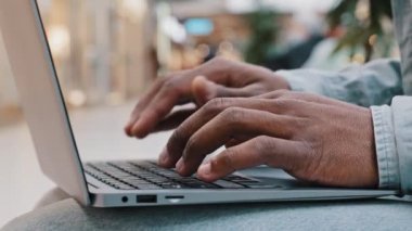 Aşırı yakın plan erkek elleri koyu tenli hacker programcısı olan tanınmayan Afrikalı adam klavye dizüstü bilgisayarı üzerinde bilgisayar serbest çalışanı kullanıcı ile online sipariş uygulaması kullanarak çalışıyor.