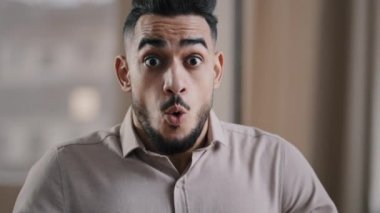 Kapatın şoke olmuş genç İspanyol erkek işadamı profesyonel işçi kameraya bakarken şaşırdı büyük gözleri mutlu etti zaferi şaşkın adam kazandı neşe dolu yüz ifadesi sergile
