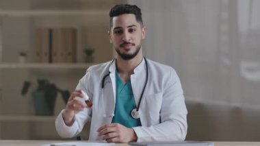 Arap genç erkek doktor İspanyol terapist burun spreyi tedavisinde burun iyileşmesi için ilaç sıvısı gösterdi. Alerji gribi belirtileri. Reklam konsepti önerilerinde bulun.