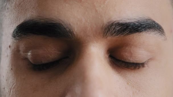 Extrémní obličejové zblízka mladé hispánské mužské oči arabský muž s hnědé oční bulvy blikající při pohledu do kamery demonstrují dokonalý zrak po oftalmologické proceduře pocit wellness helth péče koncept — Stock video