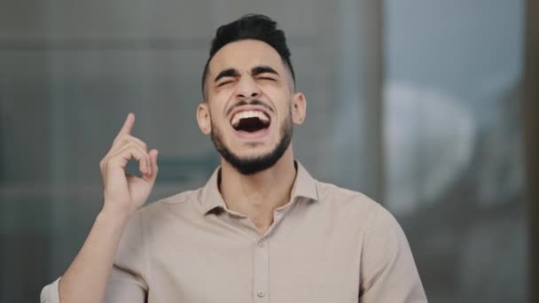 Vrolijke gelukkige Spaanse man zakenman Arabische professionele advocaat lachen luid kijkend naar camera binnen glimlachende millennial guy hebben plezier barsten lachen leuk vinden corporate grap grappige situatie — Stockvideo
