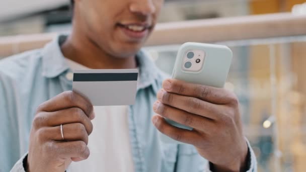 Nierozpoznawalny Afroamerykanin klient klient klient przycięty widok facet posiadający telefon bankowość karta kredytowa za pomocą aplikacji mobilnej płatności dokonać zakupu on-line płatności przelewy finansowe wirtualne pieniądze — Wideo stockowe