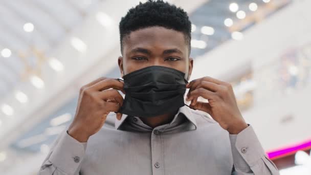 Close-up young african american man wearing medical mask protects from illness during pandemic posing adheres to precautionary measures epidemic virus covid19 outbreak protection health care concept — стоковое видео