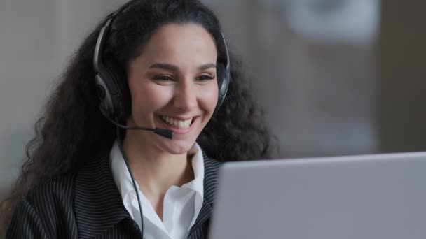 Jovem trabalhadora alegre mulher de negócios segurando videoconferência chamada com o parceiro cliente usar fones de ouvido com microfone fornecer serviço de apoio aconselha cliente hábil senhora feliz trabalhando online — Vídeo de Stock