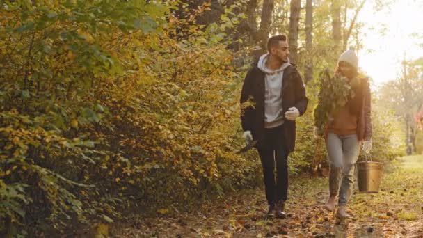 Young couple in love happy people walking in autumn park talking at sunset enjoying nature eco-activists going plant tree greening planet ecosystem protection take care plants and environment ecology — Videoclip de stoc