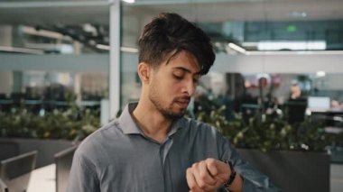Erkek portresi hayal kırıklığına uğramış Arap işadamı İspanyol işadamı ofiste görüşmeyi bekliyor. Kol saatinin geç saatlere kadar çalışmasından rahatsız oluyor. Geç kalmaktan korkuyor. 