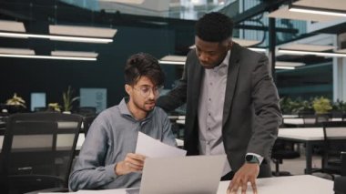 Erkek Afrikalı akıl hocası finansal danışman patron Arap erkek meslektaşının pazarlama hakkında konuşmasına yardım ediyor. Raporun sonucu, Amerikan denetçi eğitim partneri ofiste iş tavsiyesi veriyor.