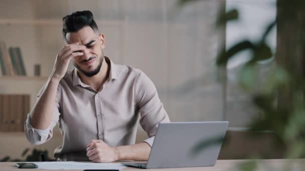 Unhappy shocked arabian male worker look at laptop screen feeling nervous upset with bad news problems study failure exam frustrated young man confused unexpected error on computer losing online bets — Vídeos de Stock