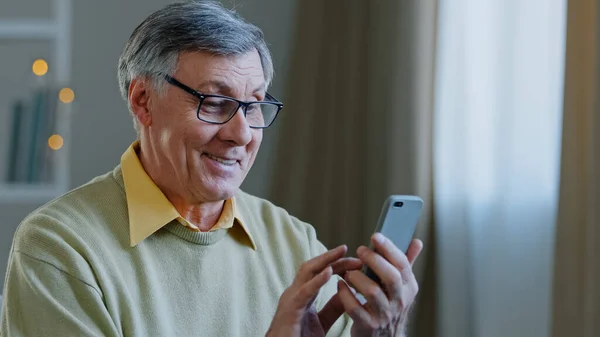 Yetişkin, olgun 60 'lı yaşlarda, telefonu olan beyaz bir erkek. Büyükbabası mobil uygulama kullanıyor. İnternetten ilaç alıyor. — Stok fotoğraf