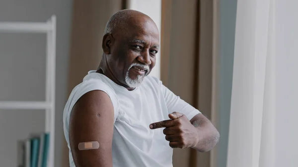 Портрет афроамериканського старого старшого зрілого пацієнта показує медичну штукатурку на ін'єкції плеча задоволений чоловік після вакцинації проти вірусу ковад-19 концепція охорони здоров'я — стокове фото