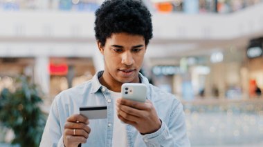 Telefonlu internet üzerinden alışveriş yapan Afrikalı Dominikli adam mobil uygulama yetkisindeki finansman sorunu nedeniyle kredi kartı numarasına giriyor. Banka alım sorununda para eksikliği reddedildi