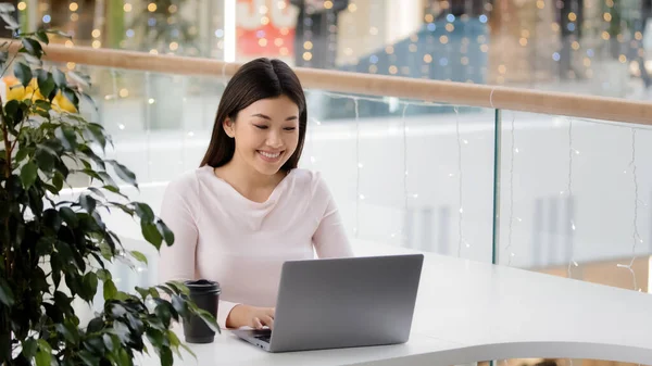 Asiatisk flicka kvinnlig student får e-post resultatet av tentor test meddelande om anställning meddelande från pojkvän i sociala nätverk på nätet tittar på laptop gärna fira seger vinnande dans sittande — Stockfoto