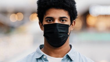 Portre erkek maskeli Afro-Amerikan adam tıbbi maskesini çıkarıyor kameraya gülümsüyor Coronavirus 'un sonunda salgın hastalıktan kurtuluyor zafer virüsü nefes almıyor