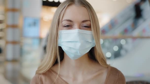 Portrait female masked face Caucasian 30s happy success woman taking off medical mask smiles indoors wide toothy looking at camera relief end of coronavirus pandemic finish covid19 recovery healthcare — Stock Video