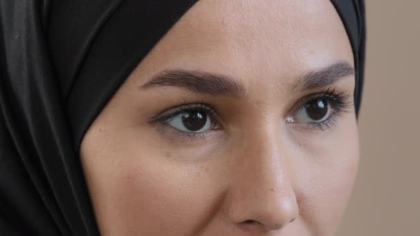 Extremo primer plano ojos femeninos árabe saudí mujer islámica modelo cara con la piel perfecta maquillaje natural en hijab tradicional mirada pestañas guiño recto buena visión después de la operación láser oftalmología — Vídeo de stock