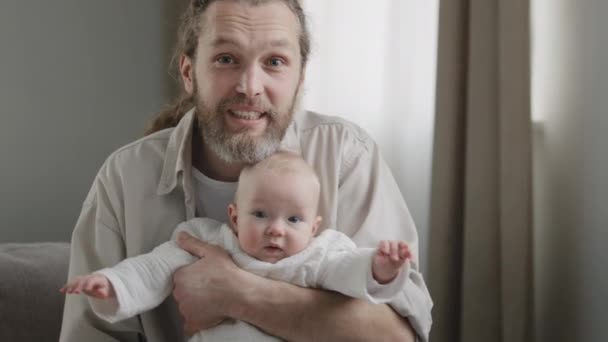 Glücklicher Vater Kaukasier mittleren Alters bärtiger Mann mit kleiner Tochter Baby Sohn neugeborenen Säugling Blick in die Kamera sprechen lächelnd nach Hause Videokonferenz Papa genießen Vaterschaft Ferngespräch — Stockvideo