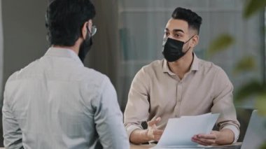 İspanyol iş adamı finansal pazarlamacı, tıbbi maske takan hasta avukat, müşteriye danış. Proje görüşmeleri, belge sözleşmesi, Coronavirüs salgınını önlemek için el sıkışın.