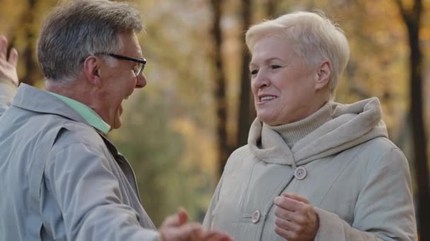 Joyful happy mature elderly couple harmony family hug in autumn park carefree talk lovely old married caucasian couple grandparents cuddle stand outdoor husband embracing wife romantic relationships — Stock Video