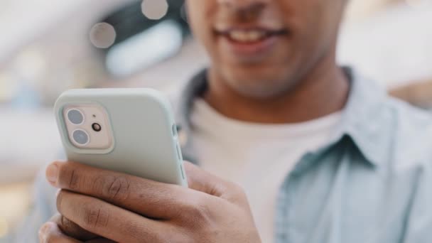 Tanımlanamayan Afro-Amerikalı adam cep telefonuyla sohbet ediyor internette geziniyor sosyal medyada online ödeme rezervasyon dağıtımı yapıyor akıllı telefon uygulaması ücretsiz 5g internet mesajları kullanıyor. — Stok video