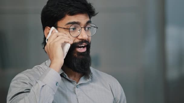 Usmívající se sebevědomí dospělý tisíciletý muž arabský podnikatel profesionální pracovník, aby obchodní hovor mluvit po telefonu v kanceláři šťastný vousatý chlap prodejce investor držet mobilní konverzaci diskutovat o projektu — Stock video