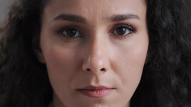 Extreme close-up bekijken vrouwelijk lichaamsdeel ernstig aantrekkelijk latino millennial vrouw gezicht natuurlijke make-up blik op camera huidverzorging behandeling in cosmetologie gezichtsvermogen zorg oogheelkunde diensten — Stockvideo