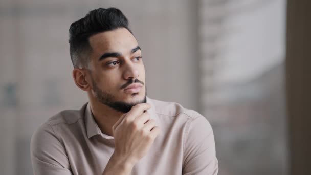 Thoughtful serious young hispanic man guy doubtful male professional worker sit at home office desk look away hold hand on chin lost in thoughts search for inspiration new idea make difficult decision — Video Stock