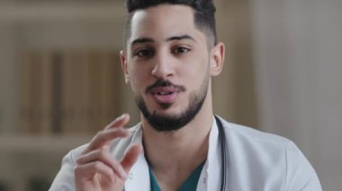Web kamera görüntüsü genç İspanyol doktor pratisyen Arap adam kamerada konuşuyor sanal konsültasyon yapın kısmen sağlık hizmetleri web sitesinden kendine güvenen adam uzaktan teletıp konseptini açıklıyor