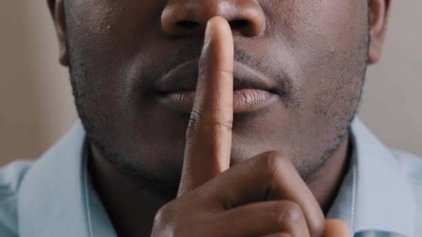 Misteriosa desconocida cara masculina parte africana americana adulto hombre poner dedo a los labios pedir silencio hacer gesto silencio mostrar secreto signo mantener secreto confidente información silencioso prohibir decir vista de cerca — Vídeo de stock