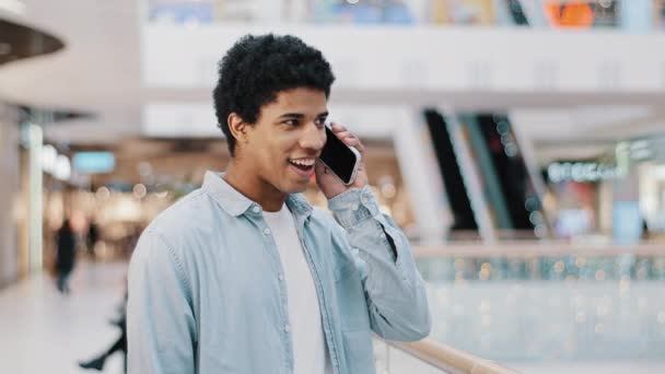 Africano dominicano cara surpreso com número de telefone tocando olhando para o homem tela respondendo chamada inesperada falando sorrindo rindo feliz bate-papo celular amigável conversa casual com boa oferta de notícias — Vídeo de Stock