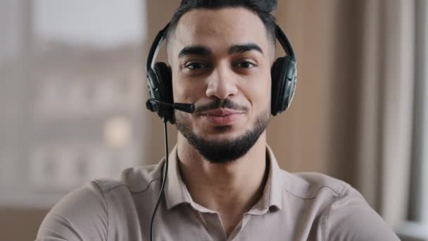 Smiling male operator hispanic businessman customer support service assistant representative greeting speak at web camera wear headset with microphone make video conference call remote job interview — стоковое видео